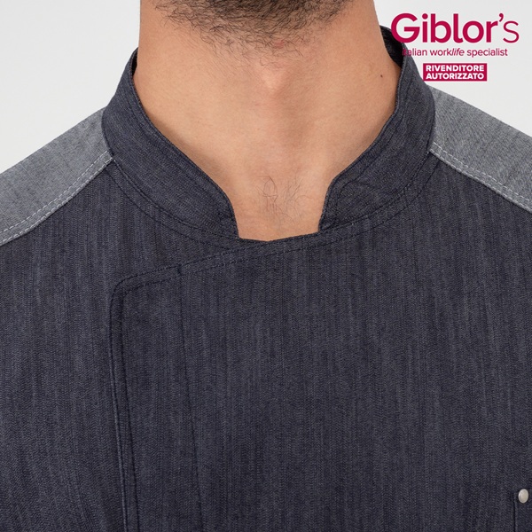 Dettaglio di giacca da chef Giblor's in tessuto denim scuro con collo alla coreana e spalle rinforzate grigie, abbigliamento professionale cucina.